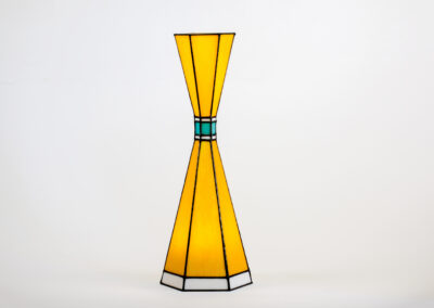 A yellow and blue stained glass vase with geometric patterns.