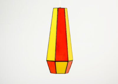 A tall, geometric vase with red and yellow vertical stripes.