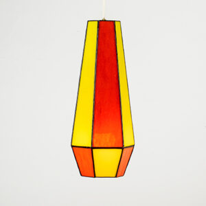 A tall, colorful stained glass vase in red, orange, and yellow.