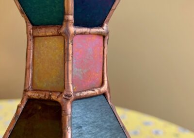 Close-up of a stained glass lamp with colorful panels.