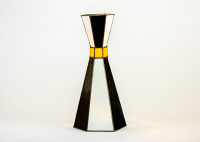 A black and white geometric vase with a yellow accent near the top.