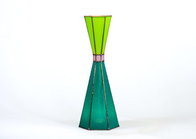A tall, green and teal geometric vase with a narrow top and wider base.