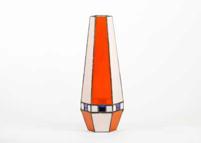 A tall vase with orange, beige, and blue geometric patterns.