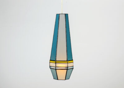 A geometric pendant light with blue, yellow, and white glass panels.